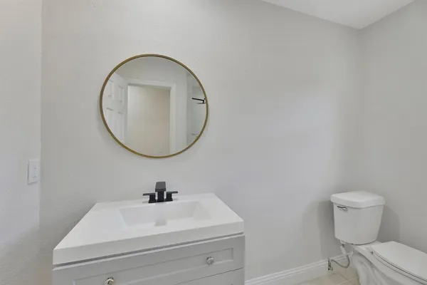 a bathroom with a sink a toilet and a mirror