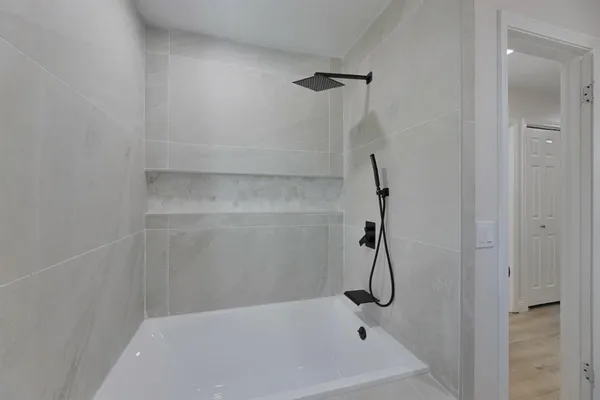 a bathroom with a bath tub with a shower