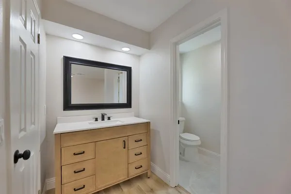 a bathroom with a toilet sink and mirror