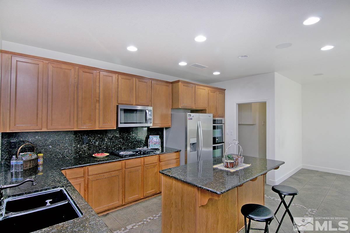 11215 Parma Way Reno, NV 89521 - Photo 11 of 22 a kitchen with refrigerator and cabinets
