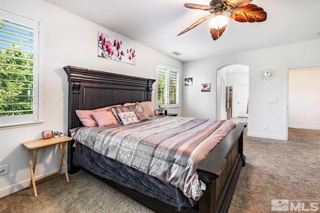 11215 Parma Way Reno, NV 89521 - Photo 16 of 22 a bedroom with a bed and a chandelier