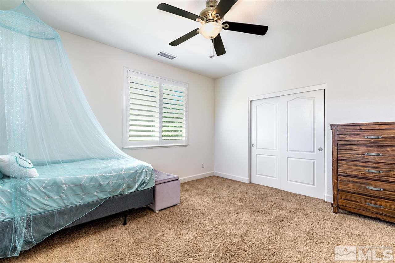 11215 Parma Way Reno, NV 89521 - Photo 21 of 22 a bedroom with a bed and a ceiling fan
