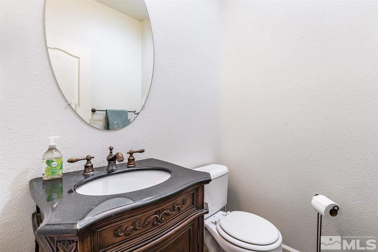 11215 Parma Way Reno, NV 89521 - Photo 9 of 22 a bathroom with a granite countertop sink mirror vanity and toilet