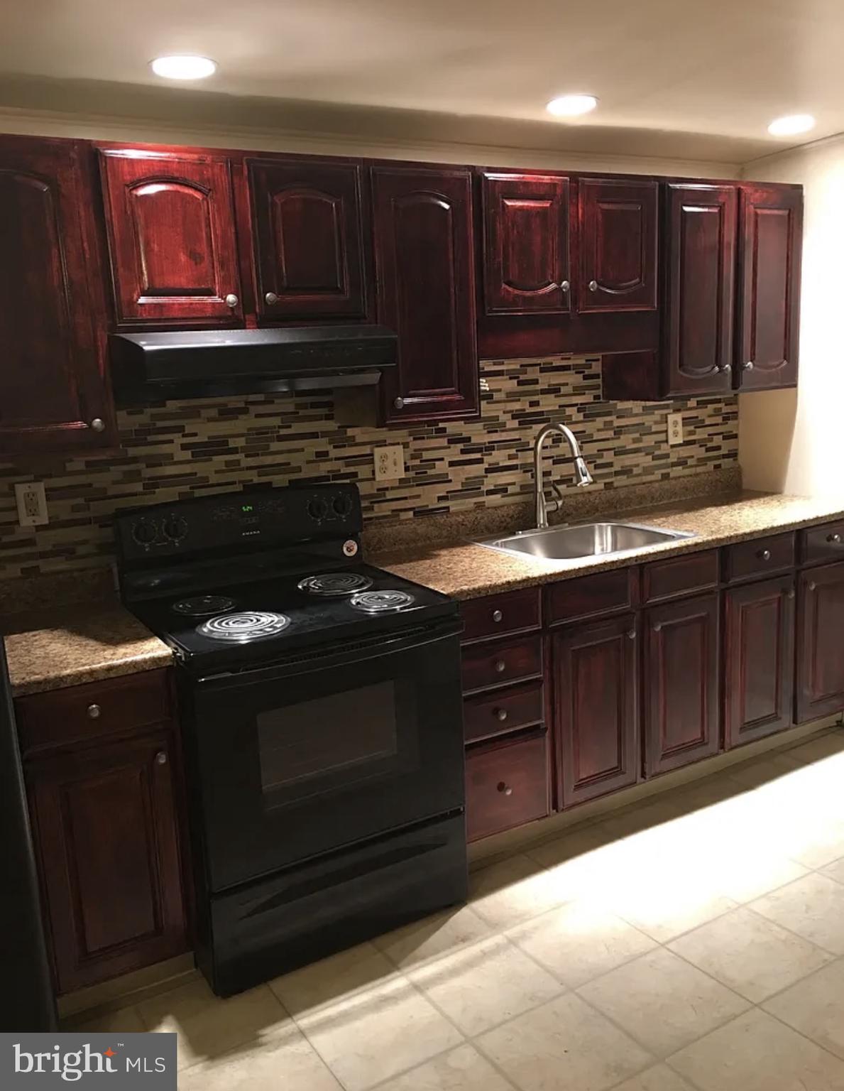 37 Olive Street Salem, NJ 08079 - Photo 2 of 19 a kitchen with granite countertop wooden cabinets and stainless steel appliances