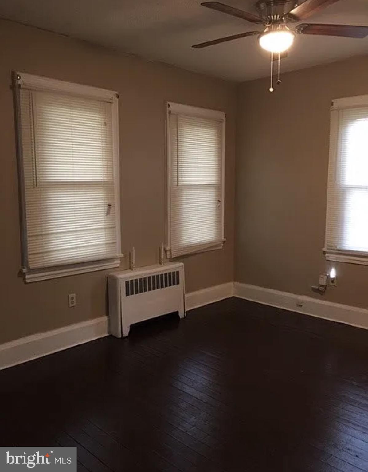 37 Olive Street Salem, NJ 08079 - Photo 7 of 19 a view of an empty room with wooden floor and a window