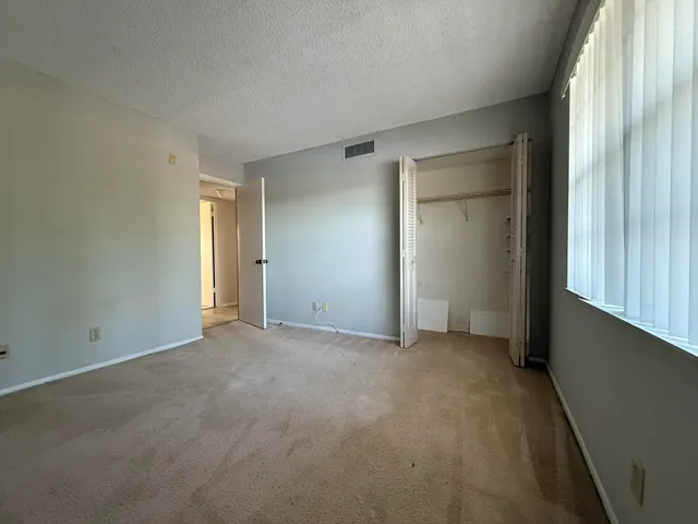 an empty room with windows and closet