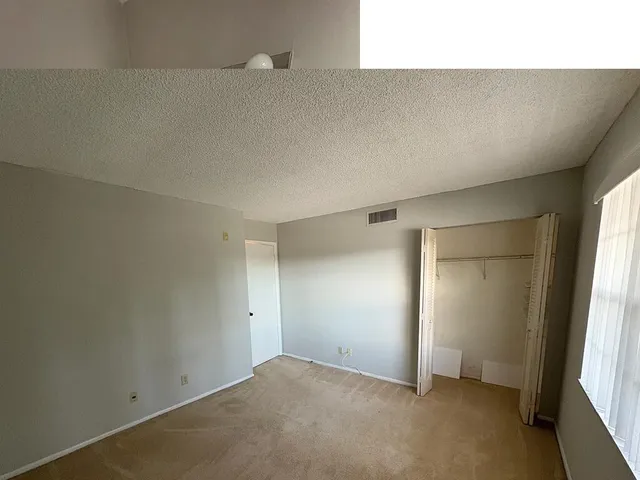 an empty room with windows and closet