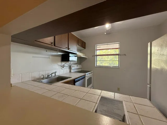 a kitchen with stainless steel appliances a sink stove and refrigerator