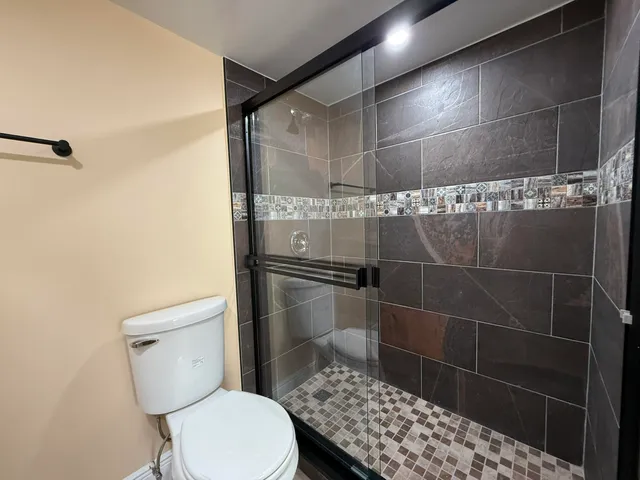 a bathroom with a toilet and a shower