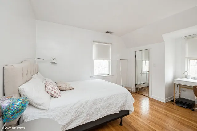 a bedroom with a bed table and a window