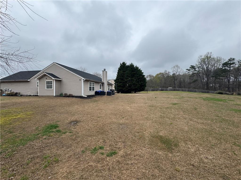 1003 Rolling Ridge Lane Auburn, GA 30011 - Photo 8 of 36 a white house with a big yard and large tree