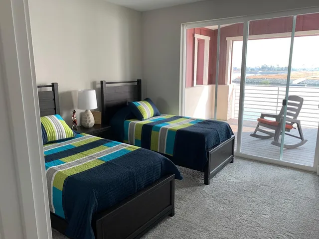 a bedroom with two beds and large window