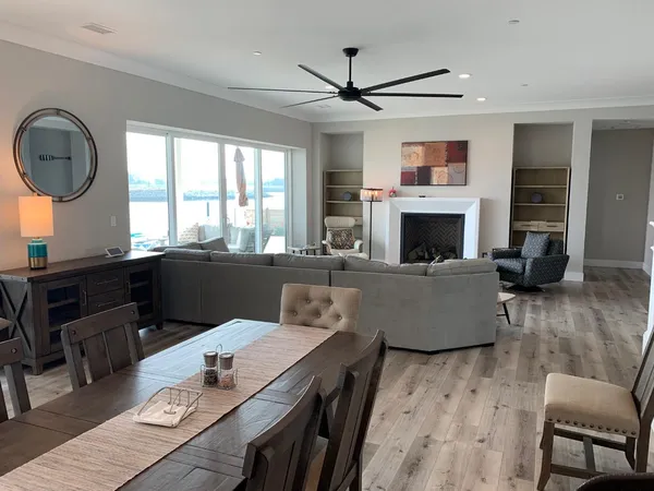 a living room with furniture a fireplace a rug and a large window