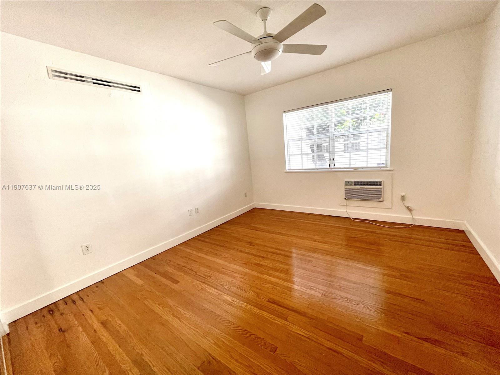 1307 Euclid Avenue, Unit 2 Miami Beach, FL 33139 - Photo 11 of 13 a view of an empty room with wooden floor and a window