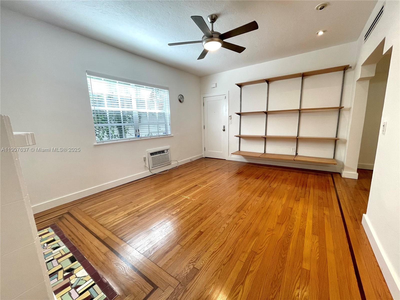 1307 Euclid Avenue, Unit 2 Miami Beach, FL 33139 - Photo 5 of 13 a view of an empty room with wooden floor and a window