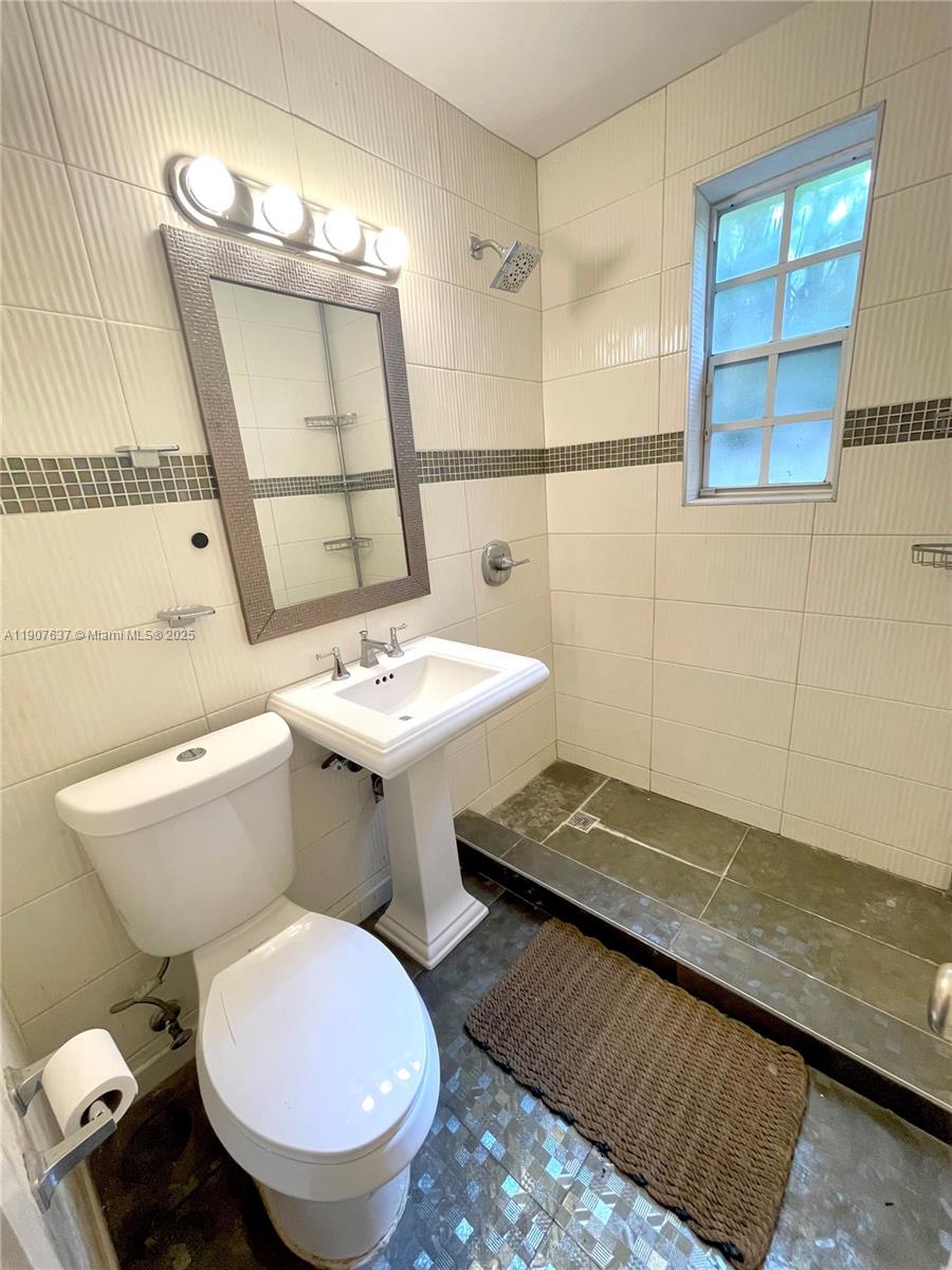 1307 Euclid Avenue, Unit 2 Miami Beach, FL 33139 - Photo 10 of 13 a white toilet sitting next to a bathroom sink