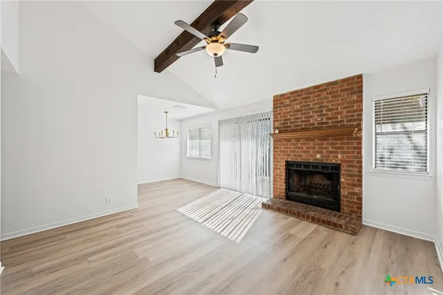 a view of empty room with wooden floor and window