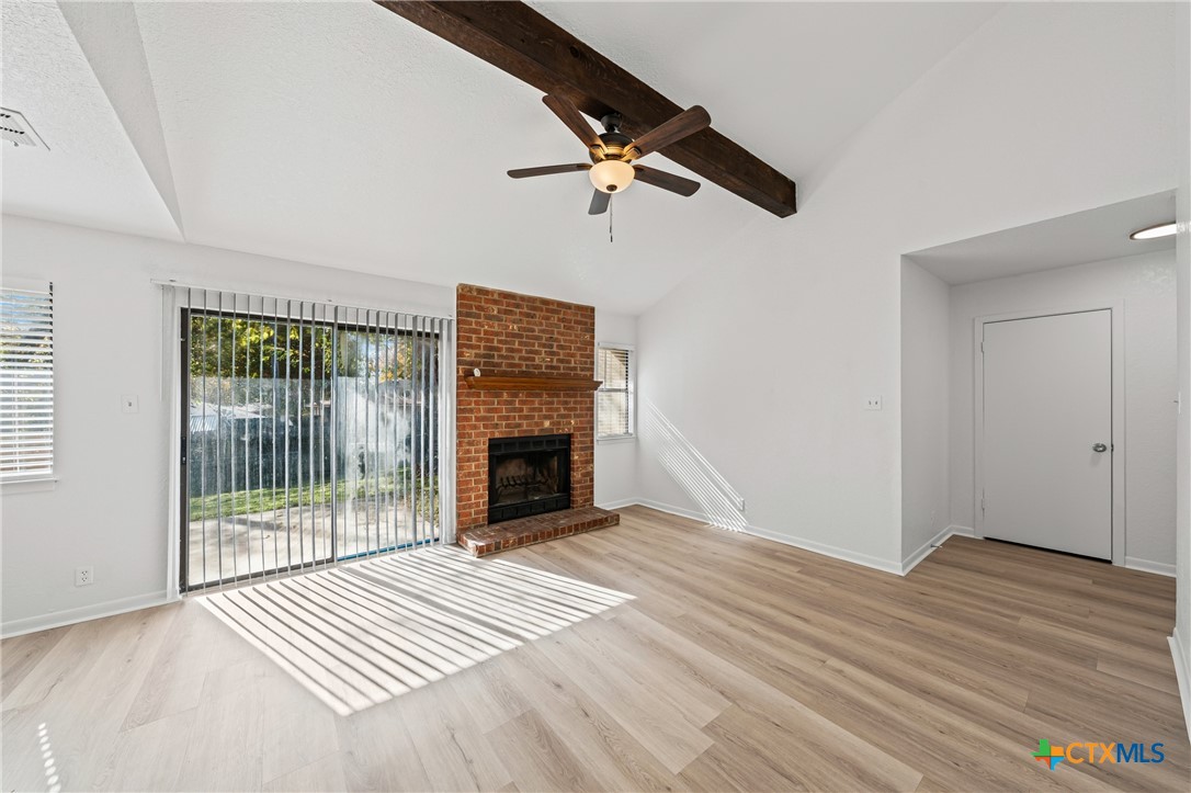 2313 Paul Revere Street, Unit A Temple, TX 76504 - Photo 8 of 22 an empty room with wooden floor fireplace and windows