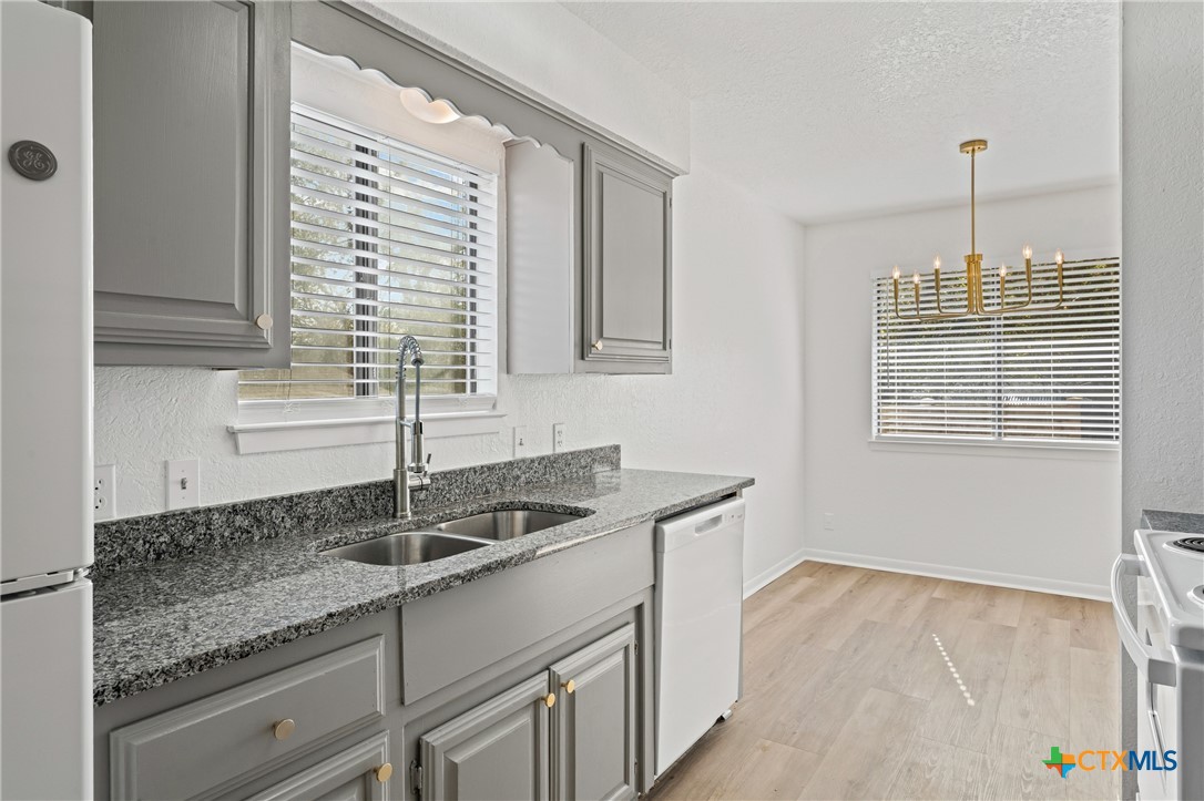 2313 Paul Revere Street, Unit A Temple, TX 76504 - Photo 10 of 22 a kitchen with granite countertop a sink and a white wooden cabinets