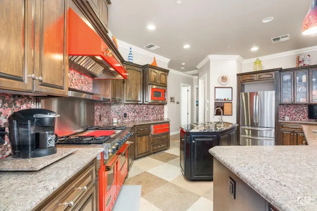 a kitchen with kitchen island granite countertop a sink stainless steel appliances and cabinets