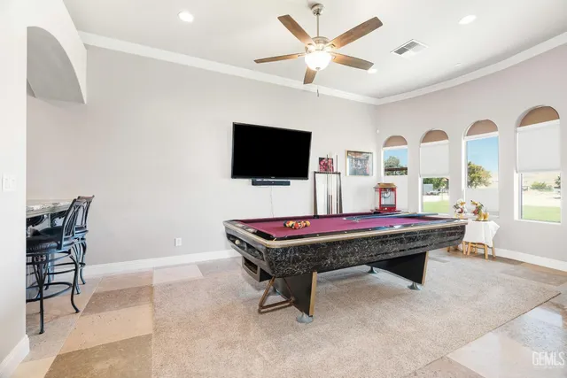 a living room with furniture pool table flat screen tv and windows