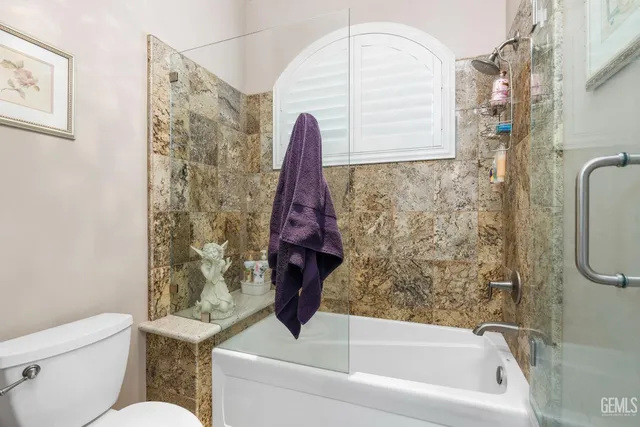 a bedroom with a bed and a flat tv screen on wall