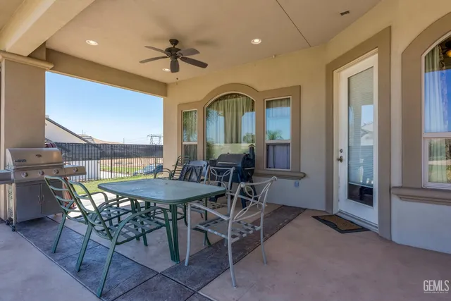 a view of a patio with a table and chairs under an umbrella
