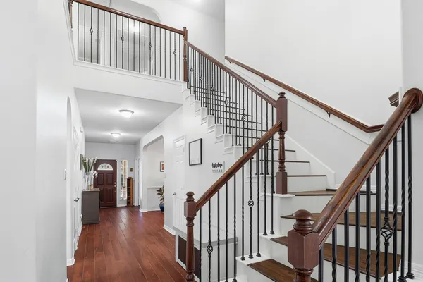 a view of staircase with lots of frames on wall and wooden floor