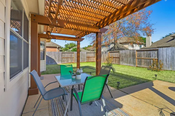 a view of a patio with a table chairs and a yard