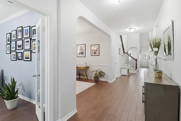 a view of a hallway with wooden floor and a potted plant