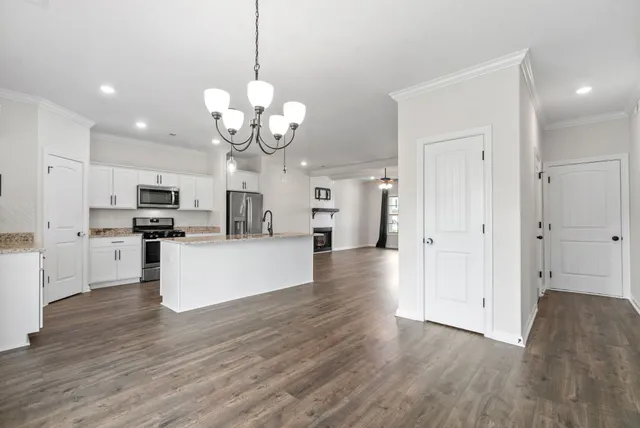 a kitchen with granite countertop white cabinets and a stove