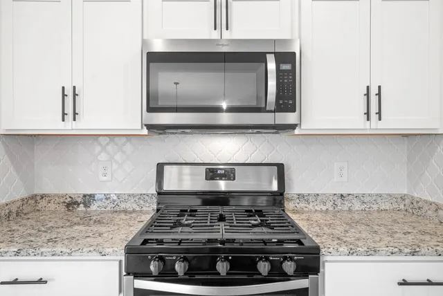 a kitchen with stainless steel appliances granite countertop wooden floors sink and cabinets