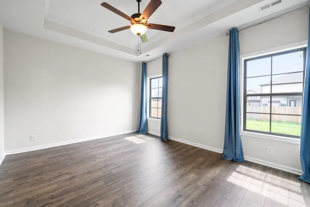 a view of an empty room with wooden floor