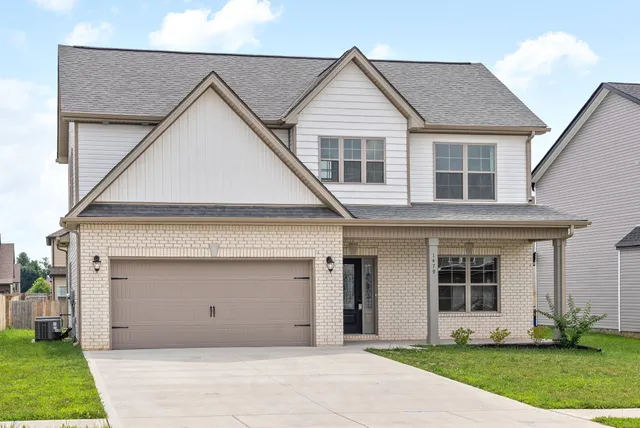 a view of a white house with a small yard and floor to ceiling windows