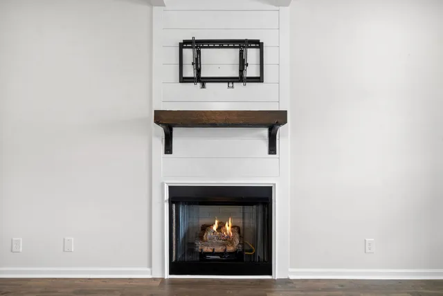 a view of an empty room with a window and fireplace