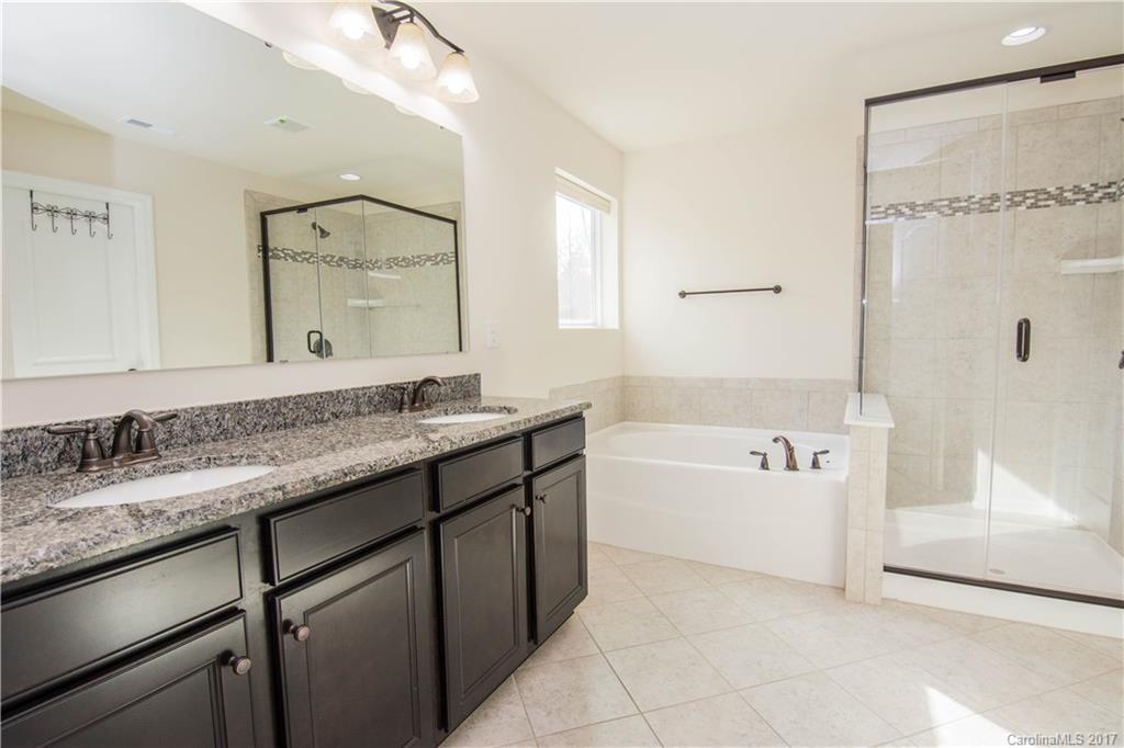 1689 Beleek Ridge Lane Clover, SC 29710 - Photo 16 of 24 a bathroom with a granite countertop bathtub a sink and a mirror