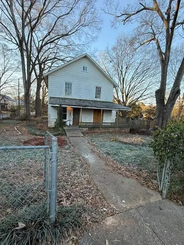 a view of a yard in front of a house with large trees