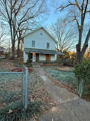 a view of a yard in front of a house with large trees