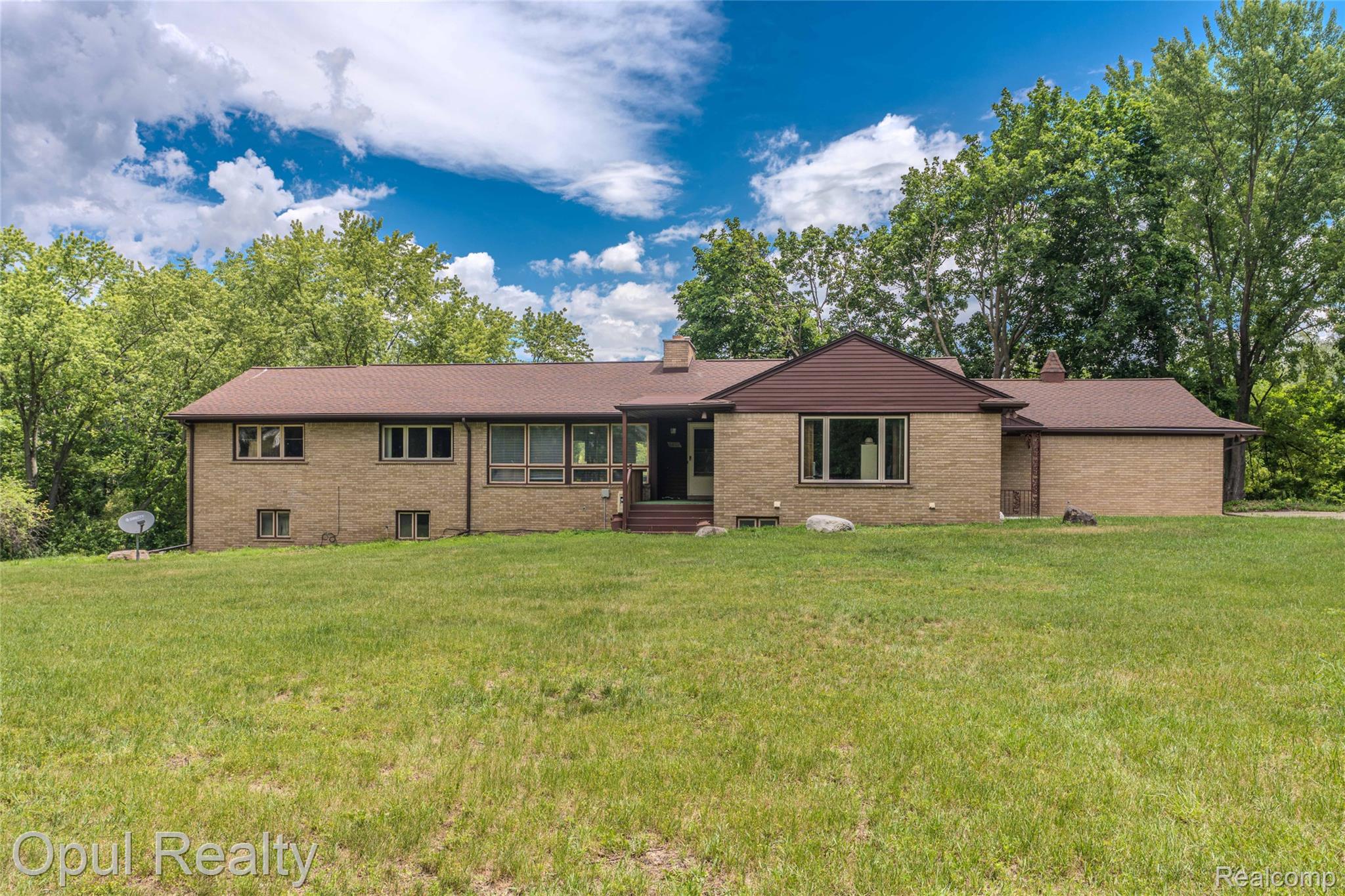 6455 Norham Road Bloomfield Hills, MI 48301 - Photo 1 of 93 Brick exterior with a brown shingle roof and contrasting brown siding accents