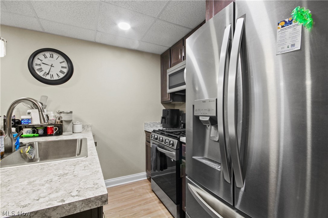 1805 East Western Reserve Road Youngstown, OH 44514 - Photo 6 of 31 Kitchen featuring sink, light hardwood / wood-style floors, a drop ceiling, and stainless steel appliances
