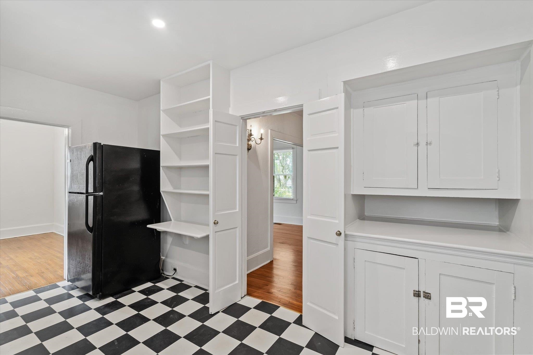 1159 Palmetto Street Mobile, AL 36604 - Photo 10 of 21 Interior space featuring white cabinets, black fridge, and light tile patterned floors