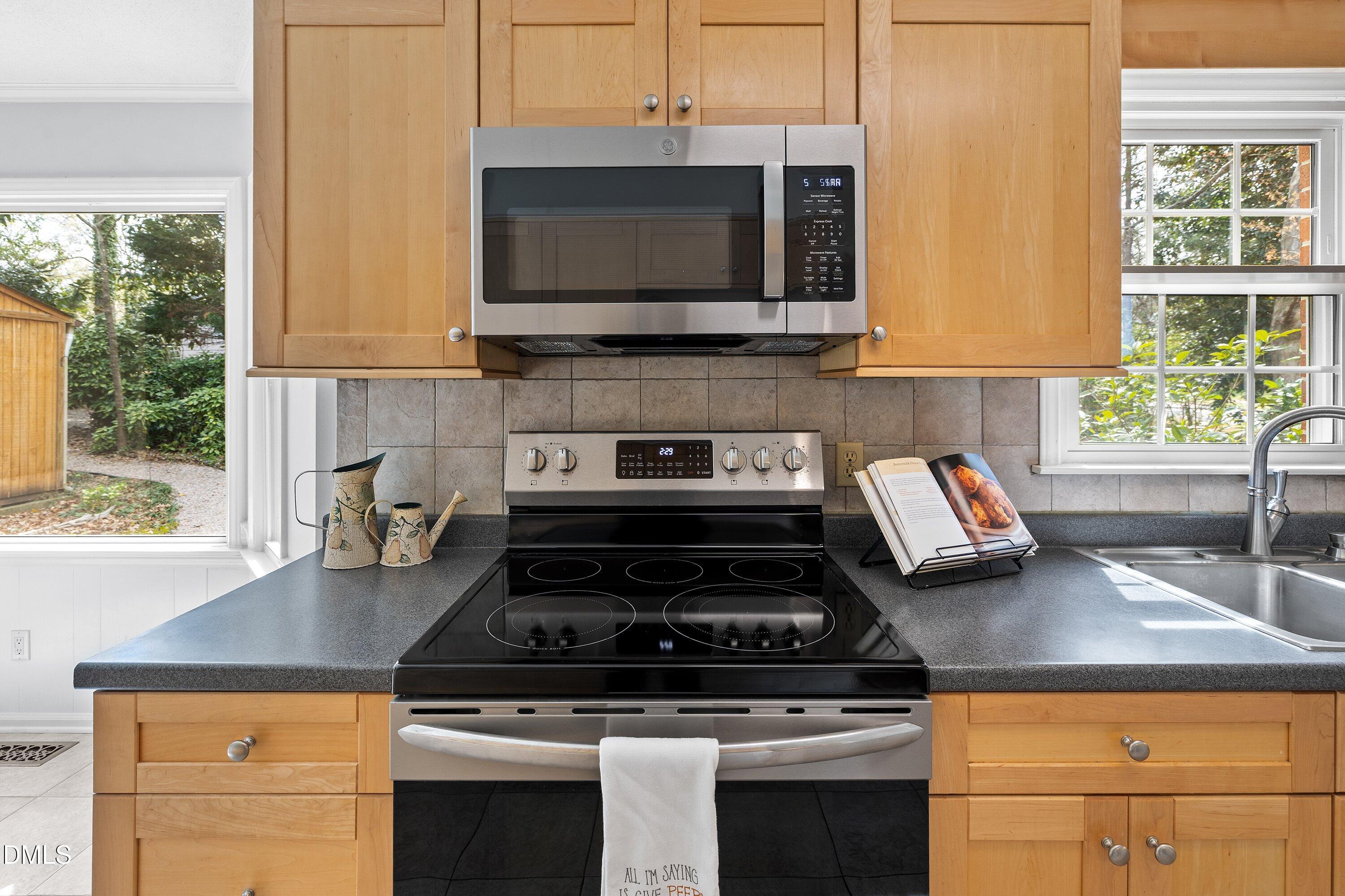 400 Cedar Hill Lane Raleigh, NC 27609 - Photo 22 of 41 a kitchen with stainless steel appliances granite countertop a stove a microwave and a sink