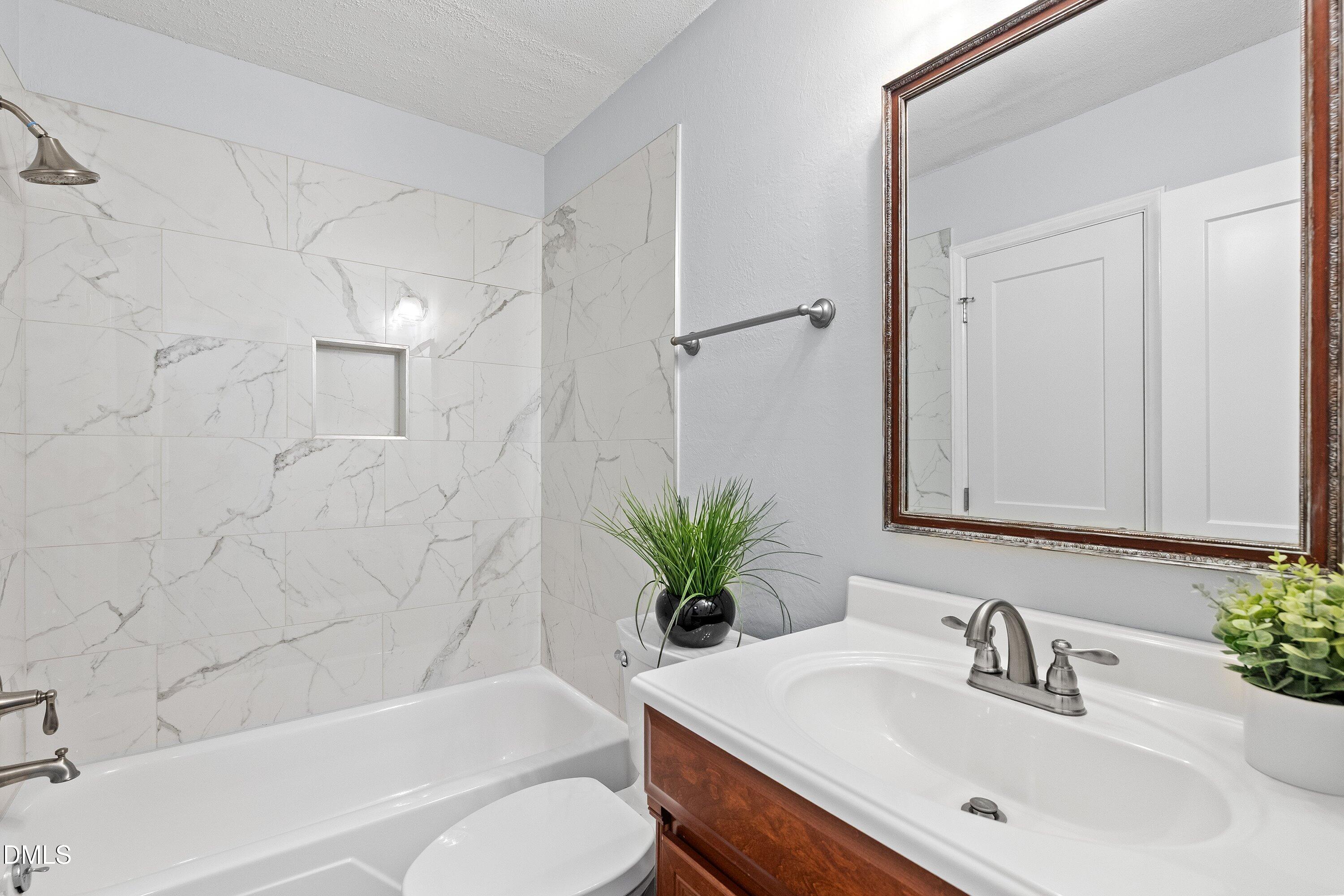 400 Cedar Hill Lane Raleigh, NC 27609 - Photo 25 of 41 a bathroom with a sink a toilet a tub and shower