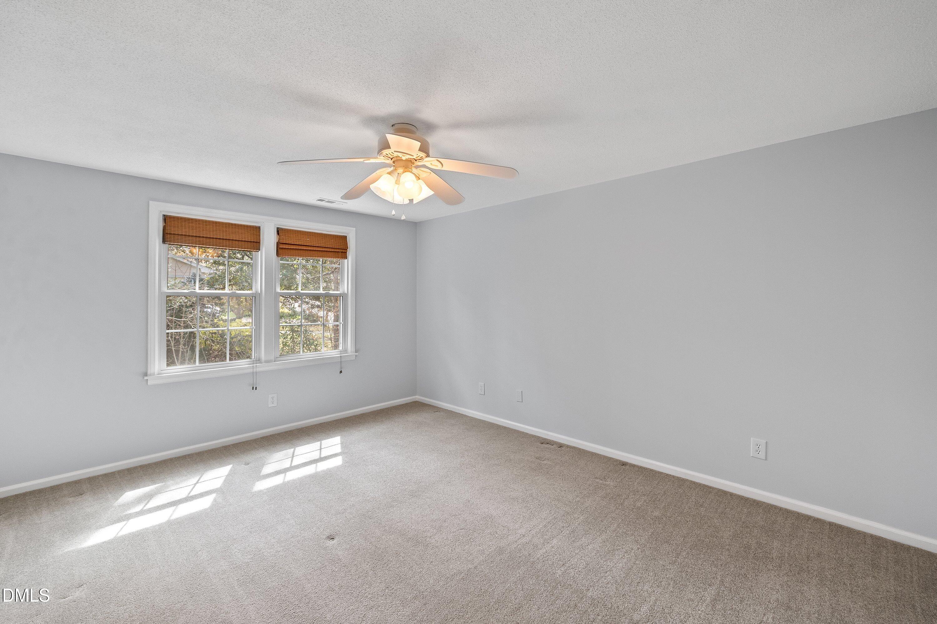 400 Cedar Hill Lane Raleigh, NC 27609 - Photo 30 of 41 an empty room with windows and chandelier fan