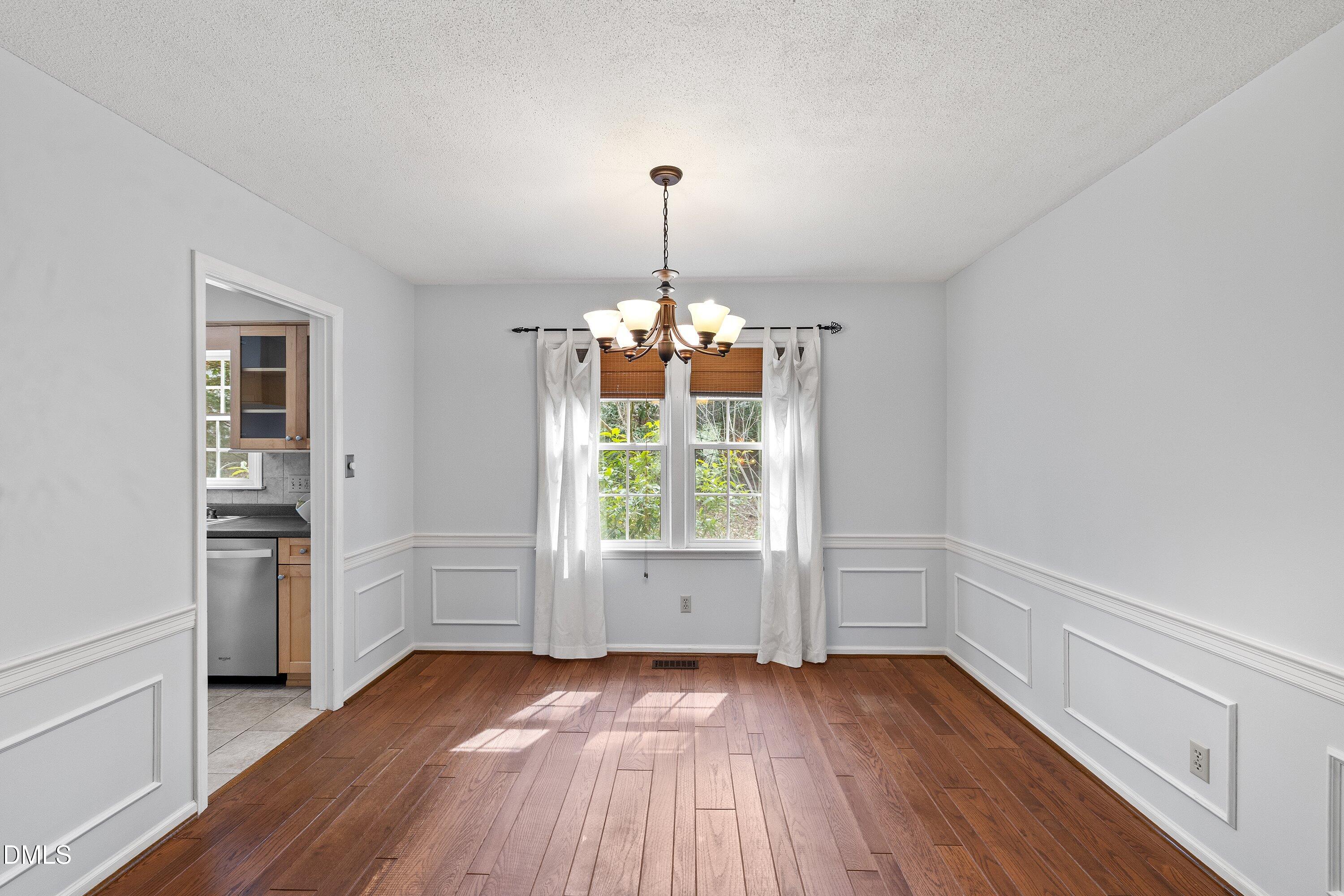 400 Cedar Hill Lane Raleigh, NC 27609 - Photo 10 of 41 an empty room with wooden floor exposed radiator and windows