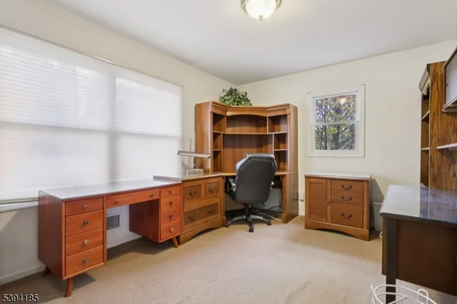 a view of a workspace with furniture and a window