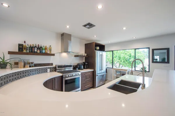a kitchen with stainless steel appliances granite countertop a sink stove and refrigerator