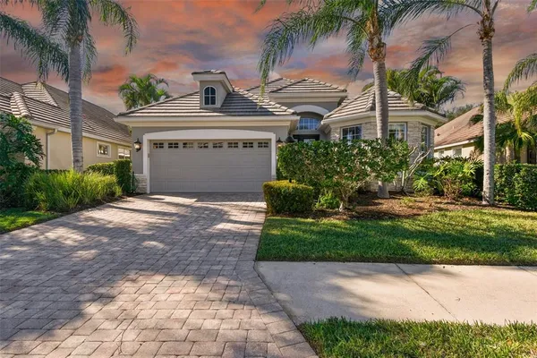 a view of a house with a yard and palm trees