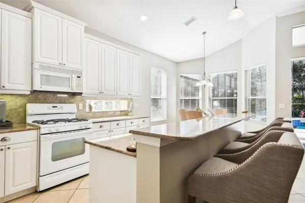 a dining room with furniture a large window and a chandelier