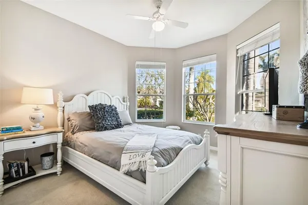 a bedroom with a bed and a dresser next to a window
